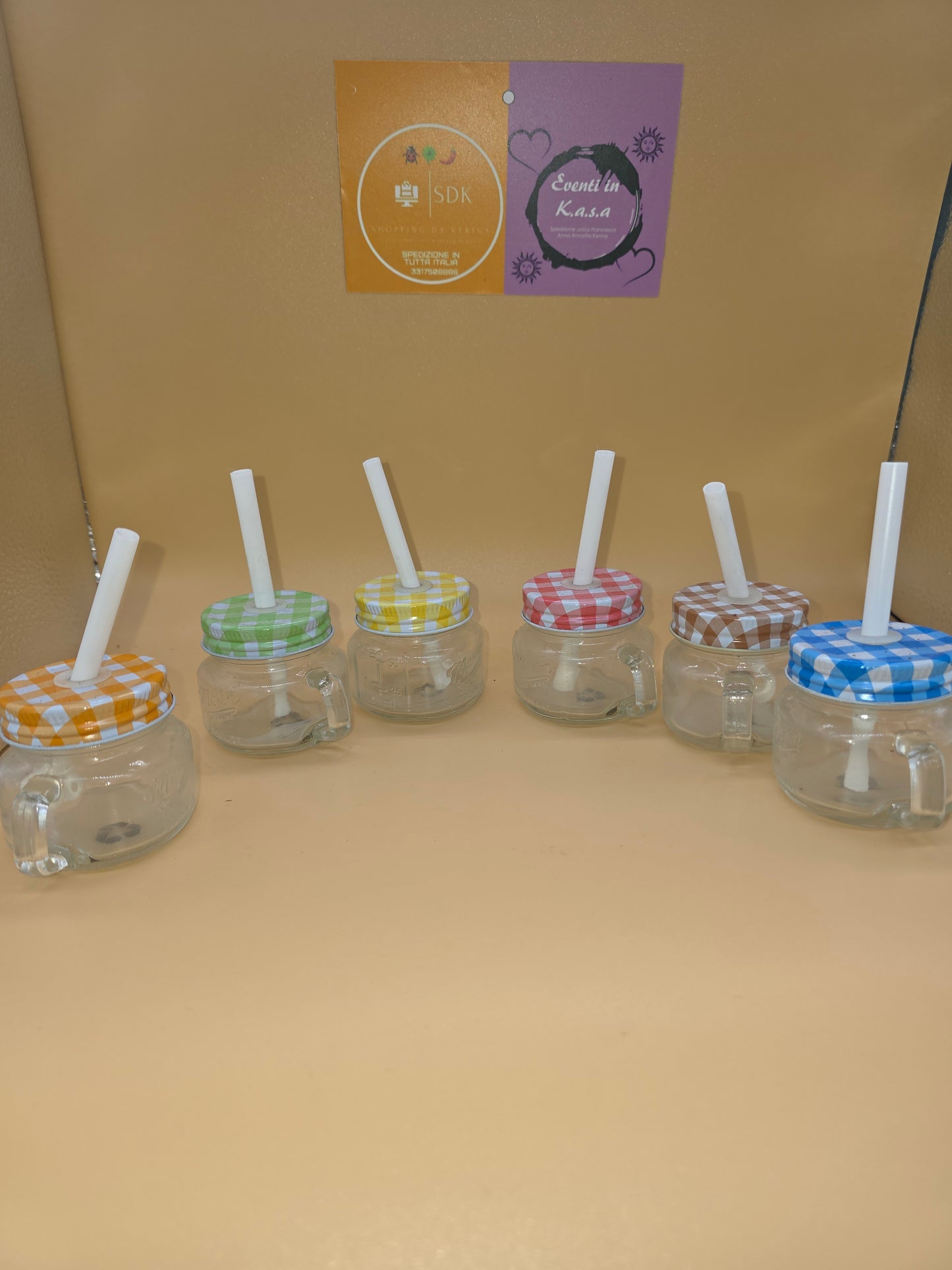 24 mini barattoli in vetro Mason Jar dotati di manico, cannuccia e coperchio colorato a quadretti.